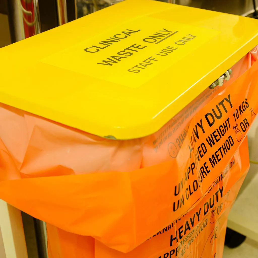 yellow clinical waste bin with an orange heavy duty bin bag inside